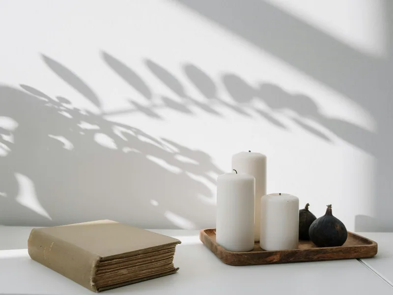 Kaarsen en boek op houten dienblad - rustige sfeer bij hypnotherapiepraktijk Soulsence Den Haag